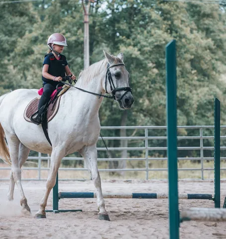 Malá jezdkyně na bílém koni na závodech Golden River Ranch Mlýnek